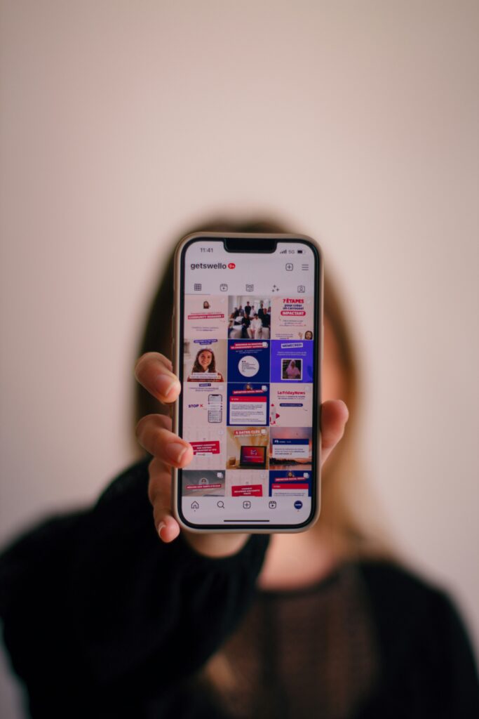 Ecran de téléphone portable affichant les réseaux sociaux avec une agence de communication digitale à reims